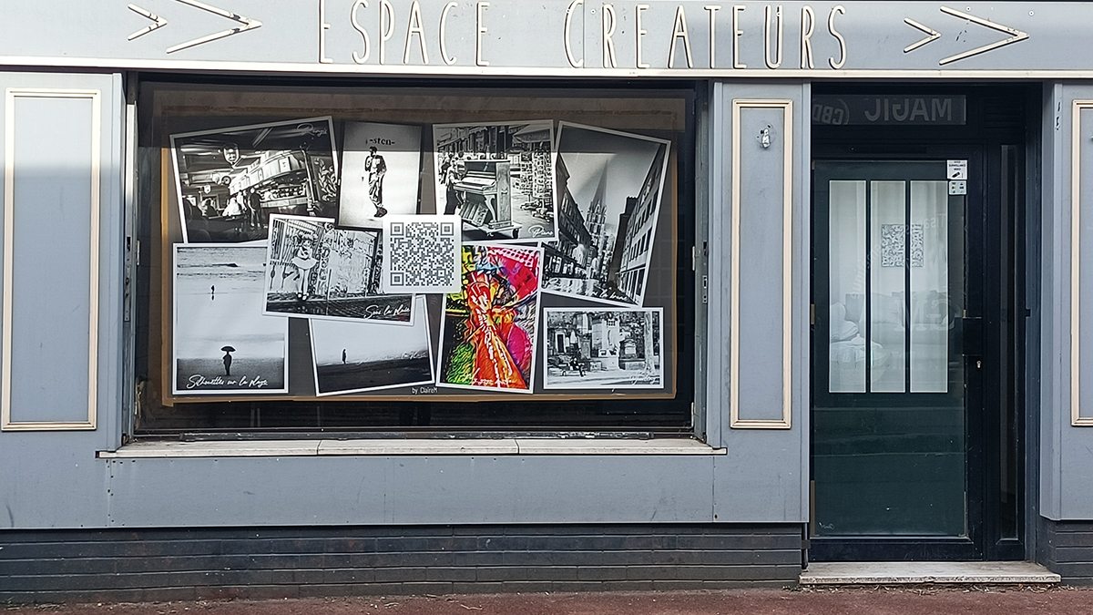 Photo de la façade et de la vitrine d'un commerce vide ; en vitrine, pour combler l'espace, un pèle-mêle géant avec plusieurs photos 